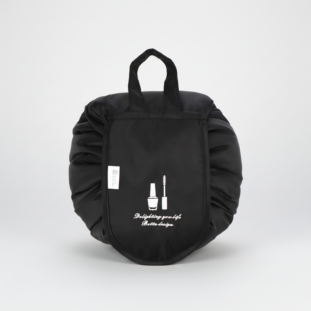 Unisex drawstring toiletry bag, GlamPouch, filled with beauty essentials, open and flat on a counter.