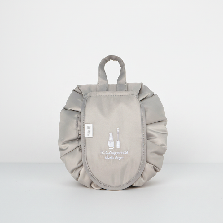 Waterproof GlamPouch makeup organizer, drawstring pouch, folded neatly for compact storage.