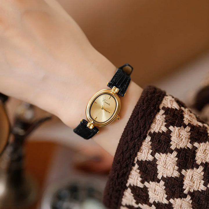 Fashion-forward unisex wristwatch with gold-tone case & buckle. Available in square and oval styles.