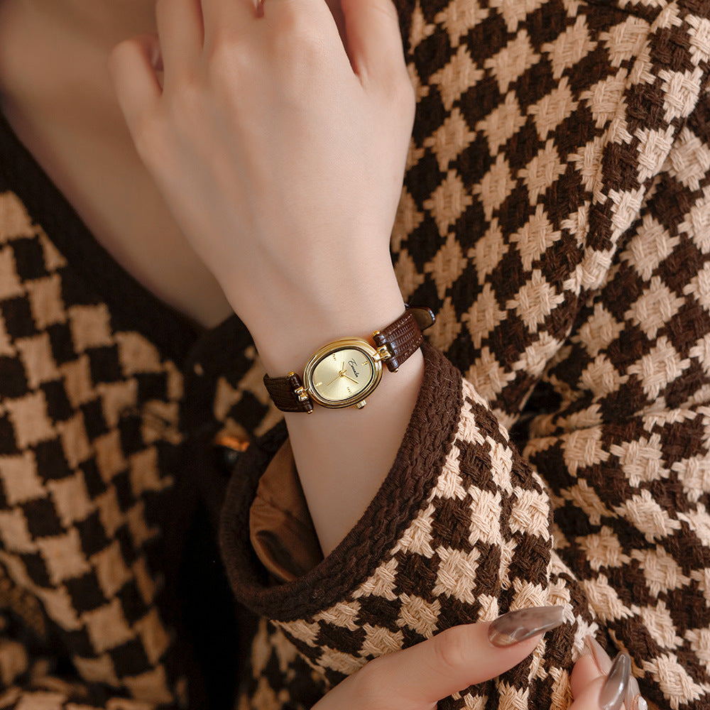 Close-up of a luxurious faux leather watch strap. Paired with an elegant gold-tone square watch face.