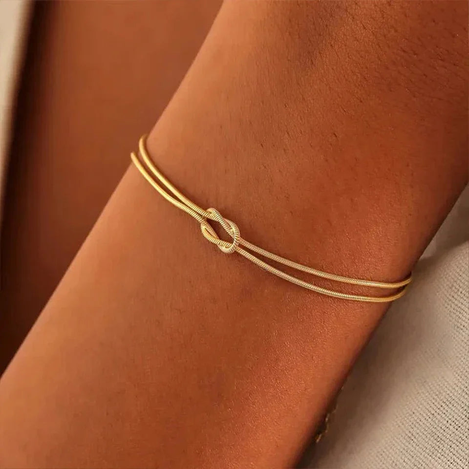 Close-up of a sleek Endless Knot Bracelet. High-quality stainless steel, adjustable, unisex design, fine jewelry.