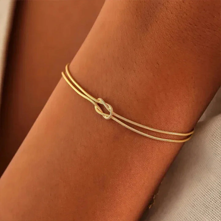 Close-up of a sleek Endless Knot Bracelet. High-quality stainless steel, adjustable, unisex design, fine jewelry.