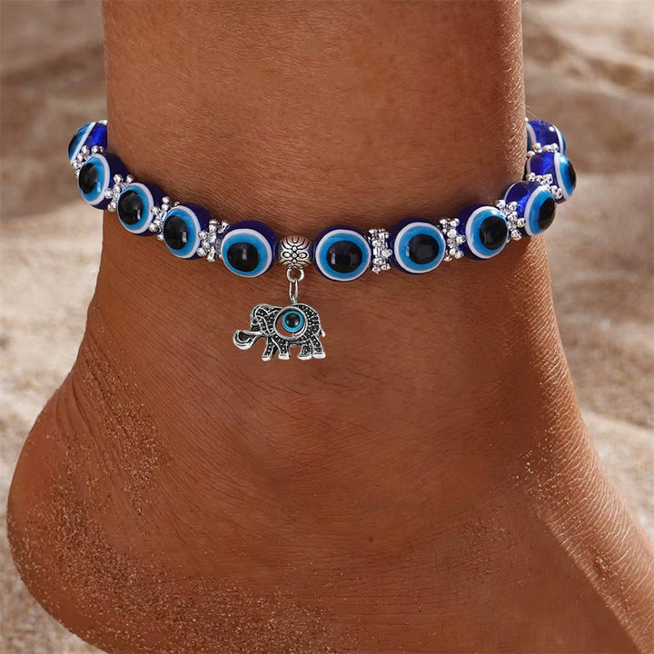 Unisex Evil Eye protection anklet styled with other symbolic jewelry for a layered look.