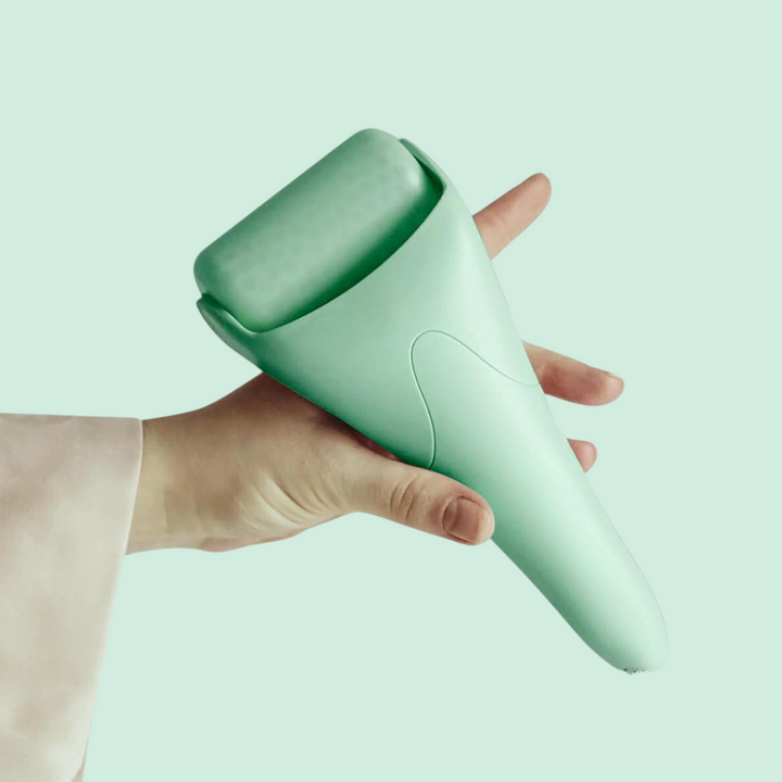 Hand holding a facial ice roller, demonstrating its ergonomic grip for comfortable face massage and puffiness reduction