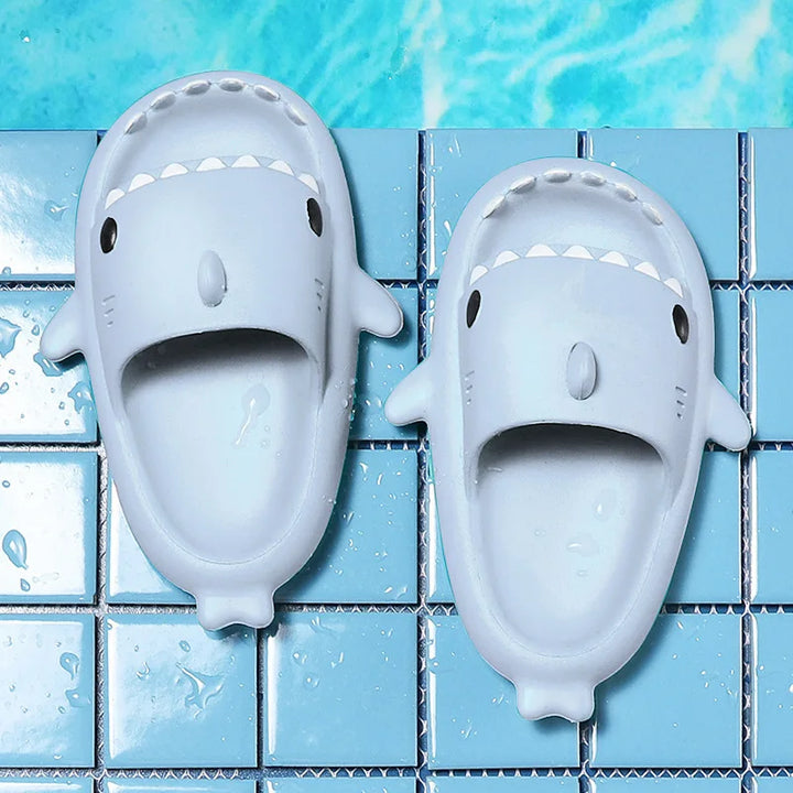 Lifestyle shot of FinSteps shark flip flops beside a swimming pool, ready for summer fun and relaxation.