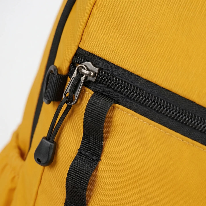 Close-up of durable ripstop fabric and zippers on a compact adventure daypack.