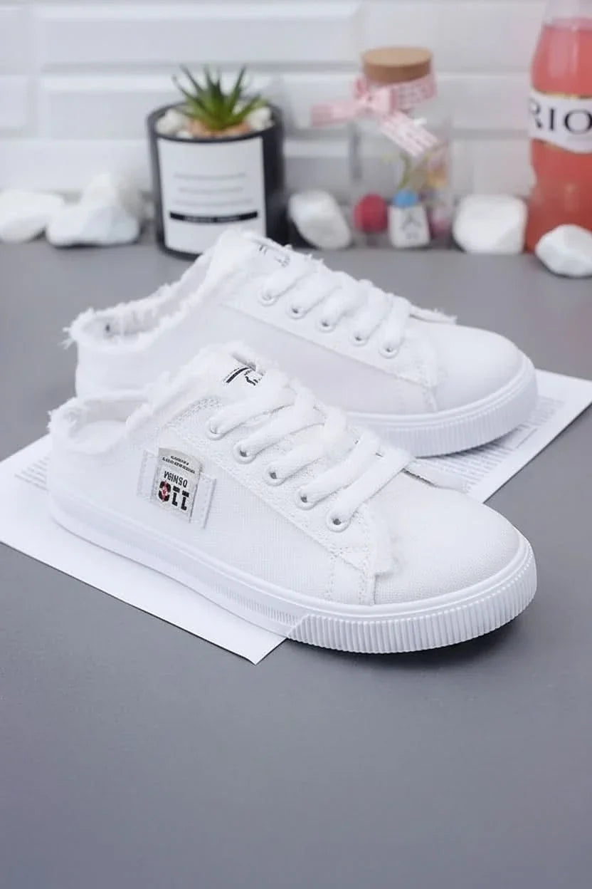 Close-up of white high-top lace-up sneakers, highlighting texture & design for casual everyday comfort.