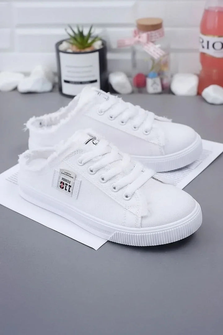 Close-up of white high-top lace-up sneakers, highlighting texture & design for casual everyday comfort.