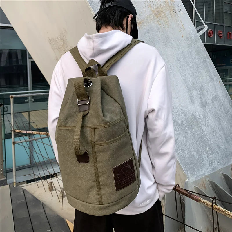 Side view of army green canvas travel backpack showing its large capacity and sturdy design.