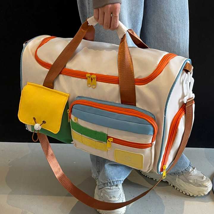 FlexaBag lightweight travel duffle bag carried by a person. Shows vibrant color block design & sturdy straps.