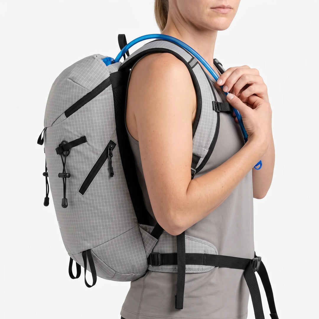 Hiker wearing a lightweight hydration backpack on a mountain trail, ready for adventure.
