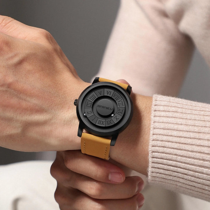Modern minimalist unisex watch with a black dial, innovative magnetic display & classic Roman numerals. Stainless steel.