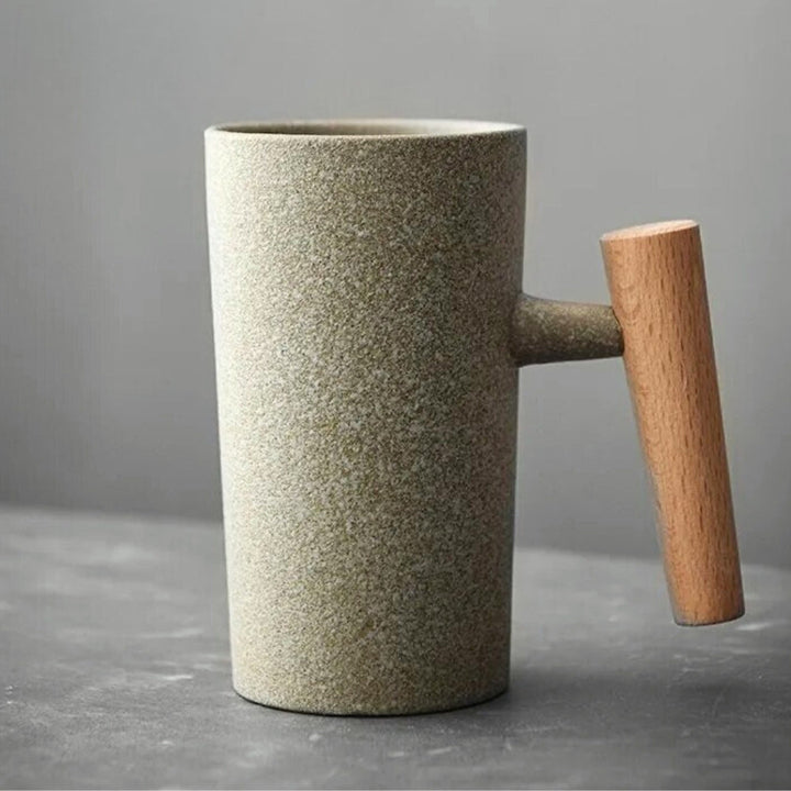 Side view of a Nordic earthenware latte mug with an earthy finish & distinctive wooden handle, kitchenware.