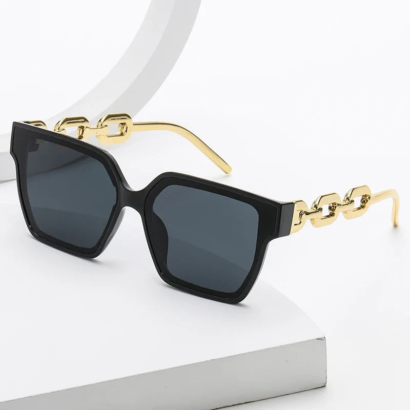 Unisex oversized sunglasses with unique gold chain temples, providing stylish UV400 eye protection and a bold fashion statement.