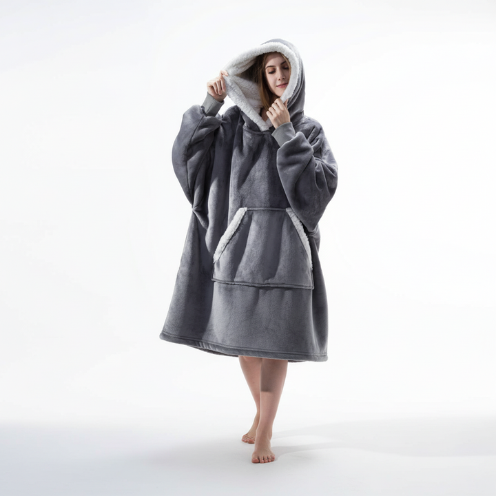 Model smiling while wearing a warm and cozy SnuggleBlanket, perfect for winter evenings