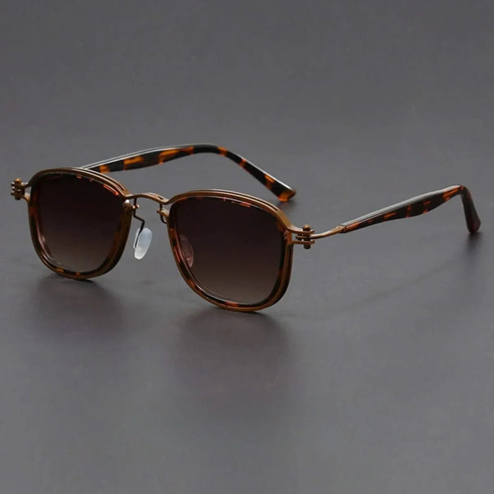 Close-up of sleek gold metal frame & black polarized lenses on unisex sunglasses. Provides UV protection.