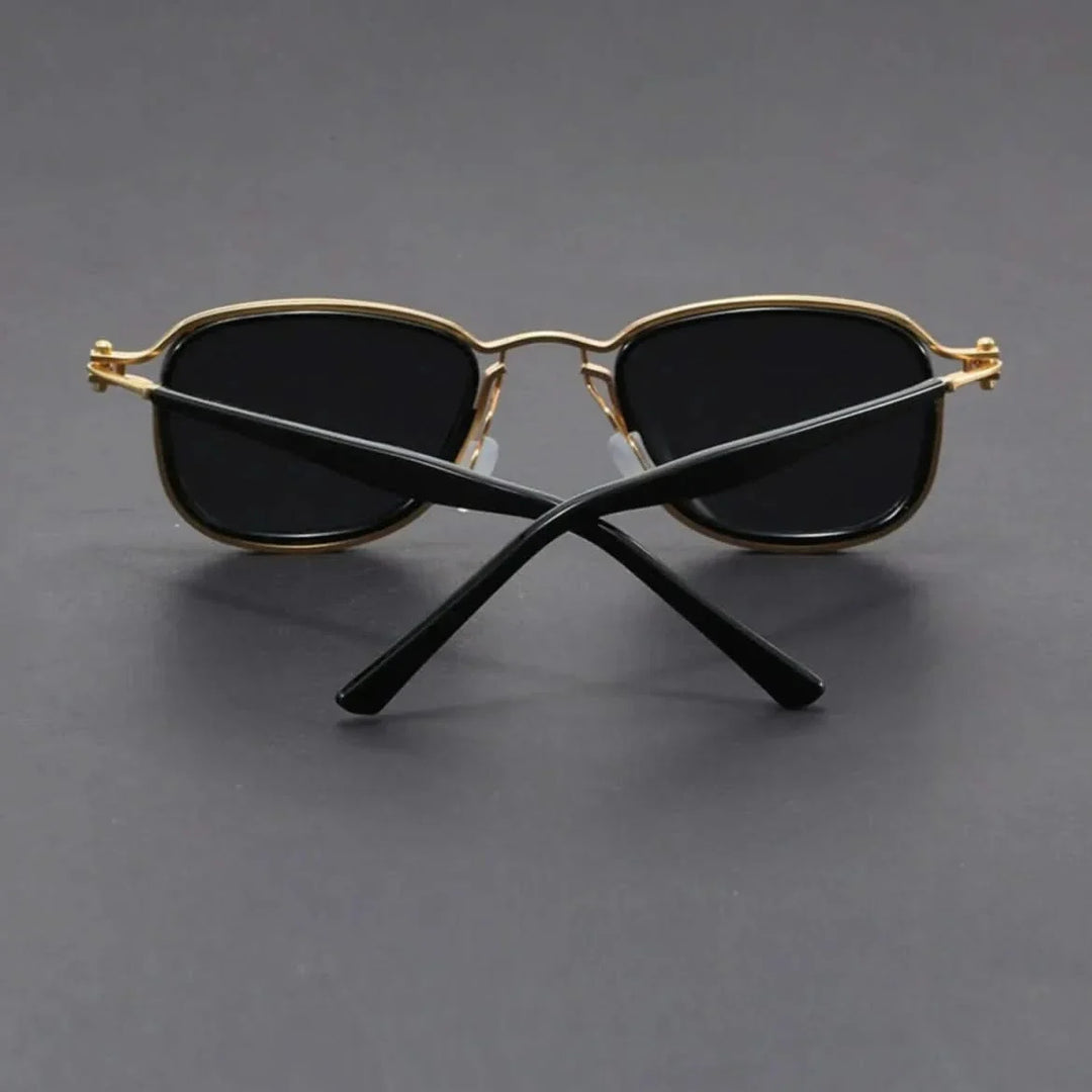 Side view of chic unisex sunglasses: gold metal frame arm with black temple tips, black polarized lenses. UV protection.