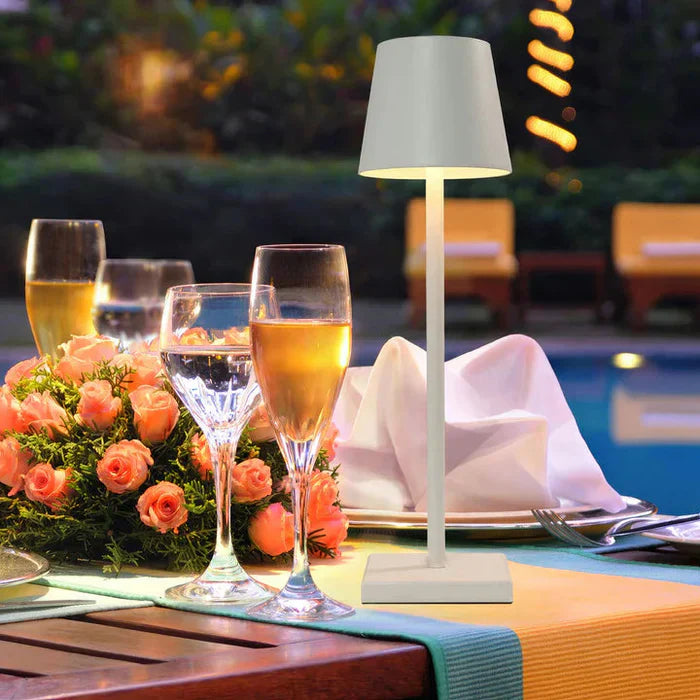 Portable LED table lamp illuminating a cozy outdoor setting, showcasing its dimmable feature