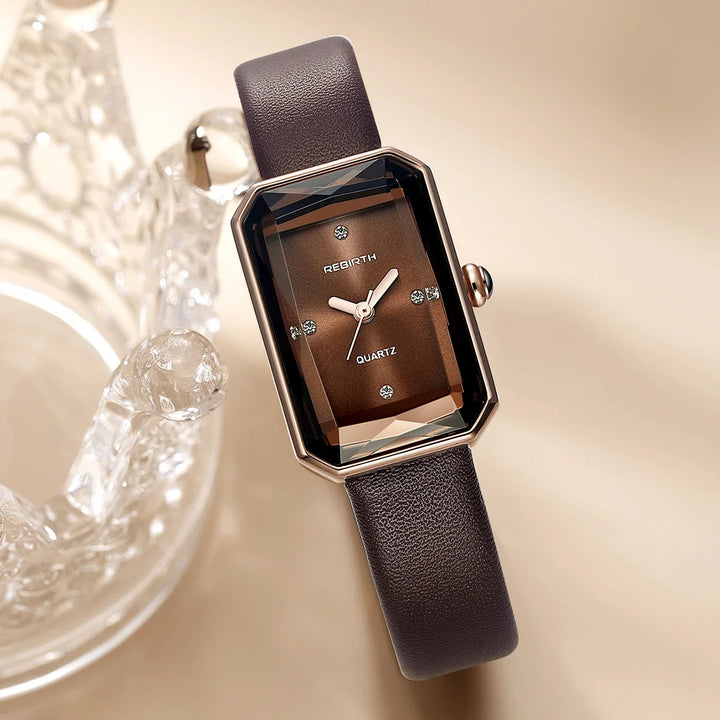 Close-up of classic rectangular watch dial, featuring clear markers and elegant hands.