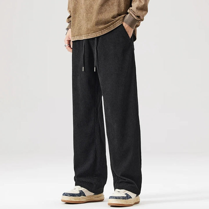 Breathable unisex relaxed fit corduroy pants with wide leg & drawstring waist for comfort.