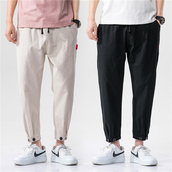 Close-up of lightweight linen blend fabric on relaxed fit unisex trousers, highlighting breathable summer texture.