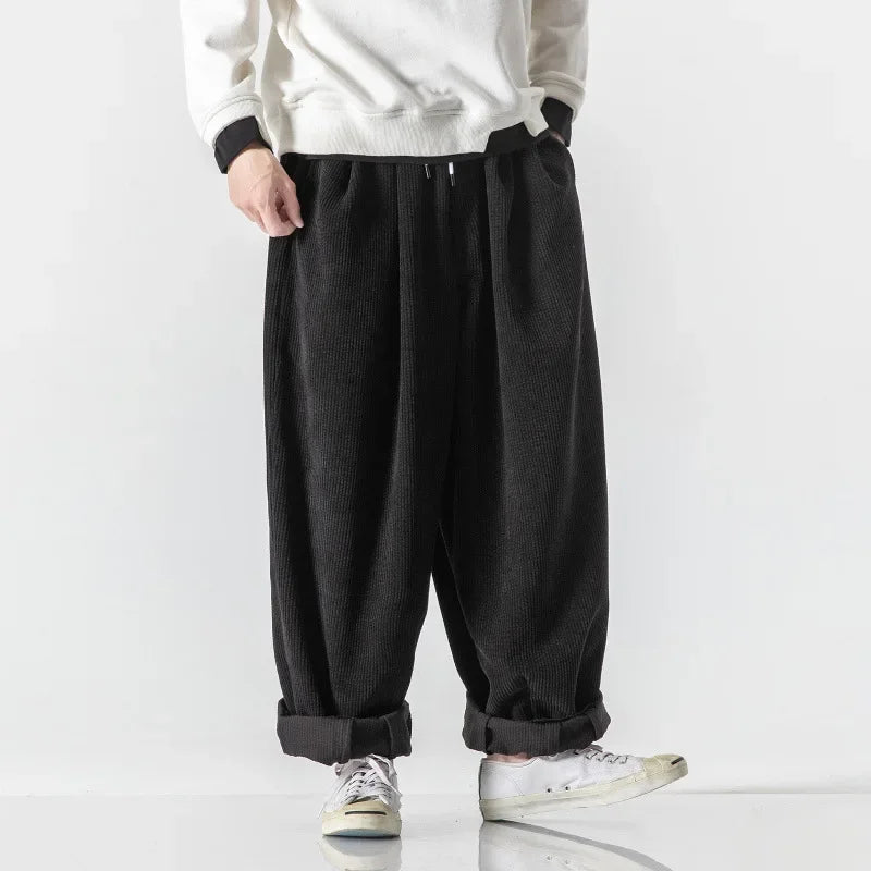 Unisex model wearing relaxed fit black lounge sweatpants, showcasing comfortable daily style.