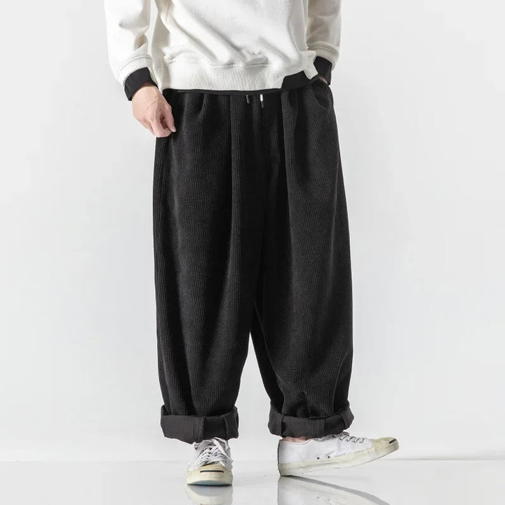 Unisex model wearing relaxed fit black lounge sweatpants, showcasing comfortable daily style.