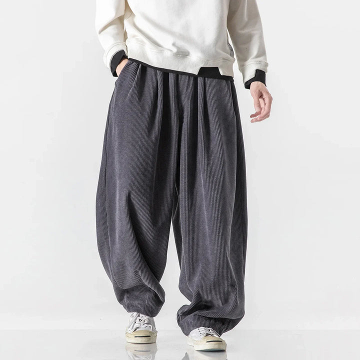 Black relaxed sweatpants, unisex design with side pockets, ideal for casual style & comfort.
