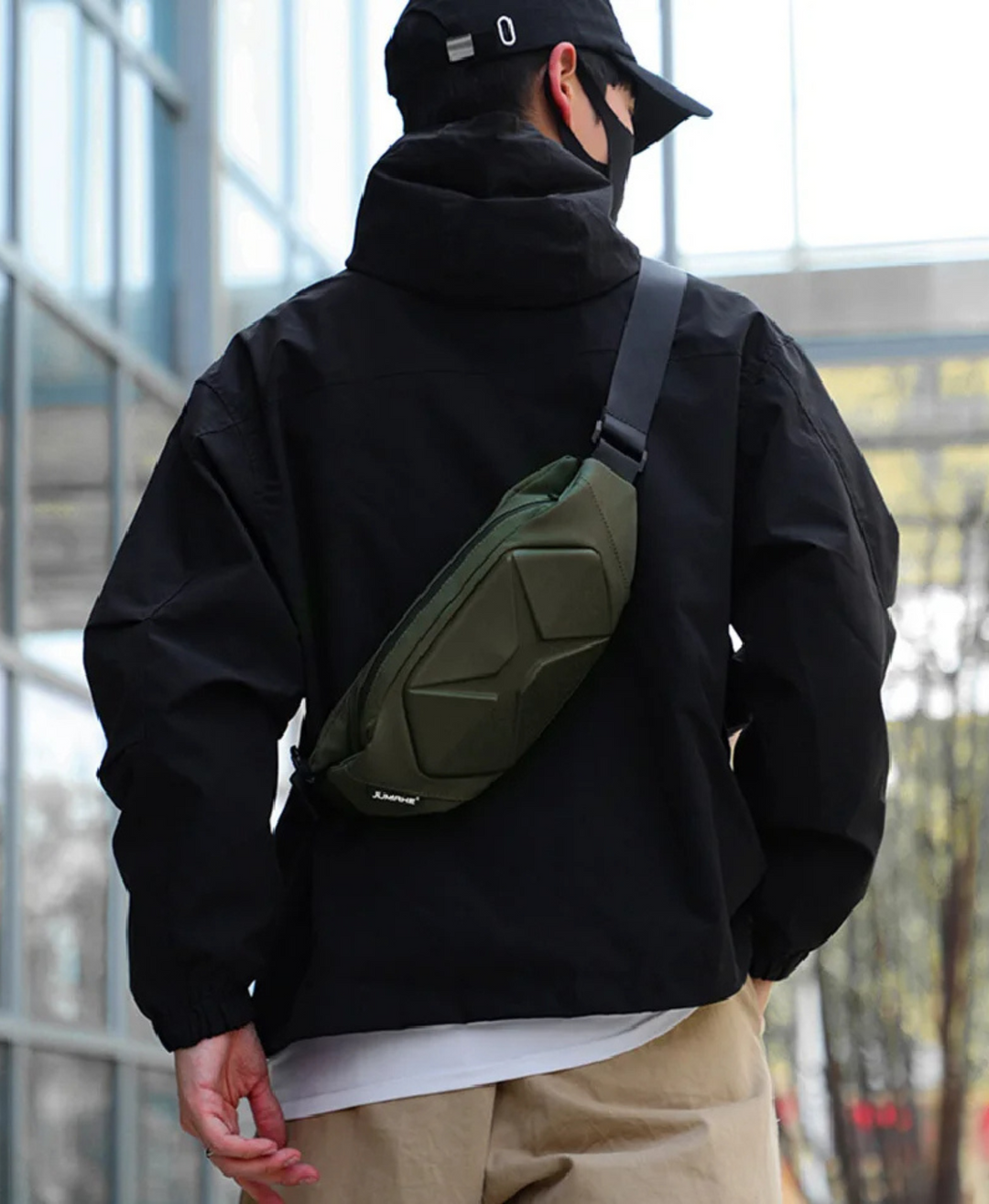 Close-up of black unisex hardshell tactical crossbody bag, water resistant & durable design.