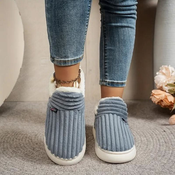 Soft, fuzzy thermal house slippers. Unisex indoor footwear providing cozy winter warmth and non-slip safety.