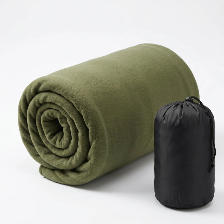 Ultralight fleece sleeping bag liner flat lay with camping gear. Portable, cozy addition for outdoor adventures.