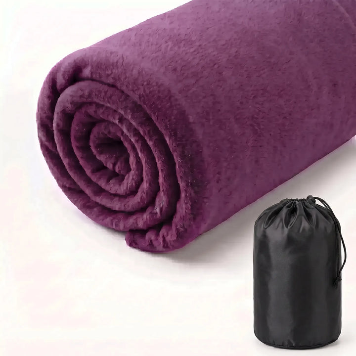 Ultralight fleece sleeping bag liner attached to a hiking backpack. Essential portable gear for outdoor adventures.