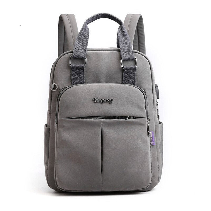 Side view of water-resistant travel bag, featuring USB charging port