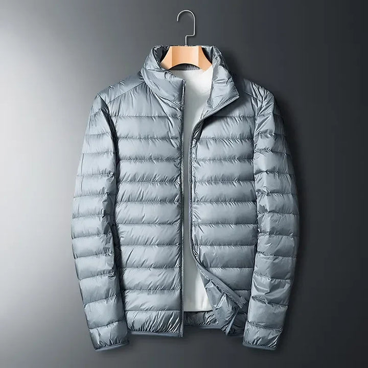 Unisex white packable winter jacket for cold weather. Lightweight, waterproof, & durable travel essential outerwear.