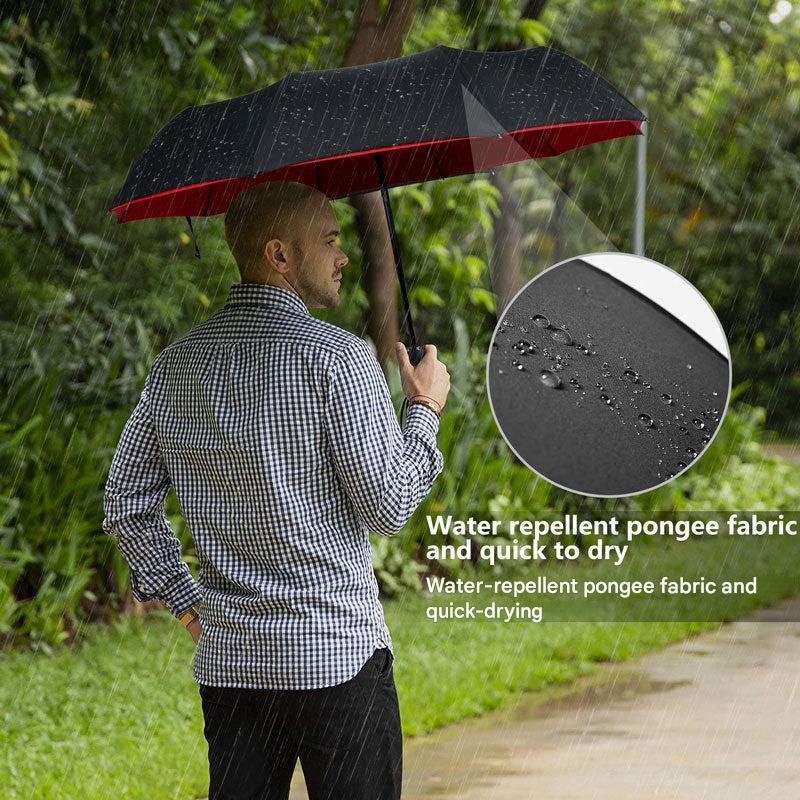 Unisex AeroShield compact travel umbrella protecting a person from rain and wind on a city street