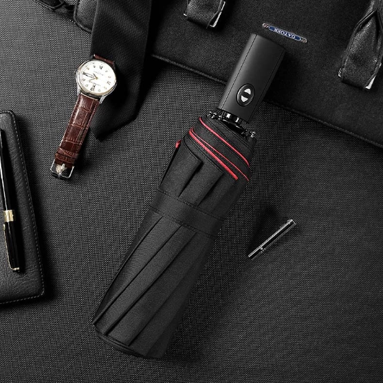 Foldable travel umbrella, AeroShield, being held in hand, demonstrating its compact size and grip