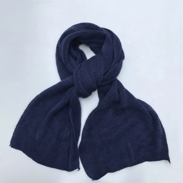 A person wearing a cozy beige cashmere scarf, demonstrating its soft and warm qualities in winter
