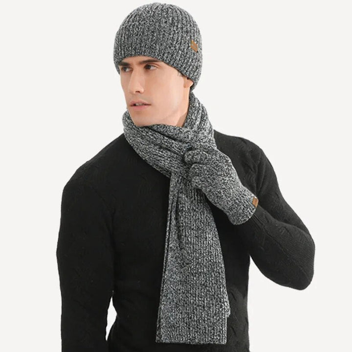 Unisex gray winter gift set: a soft knitted hat, coordinating scarf, and comfortable gloves.