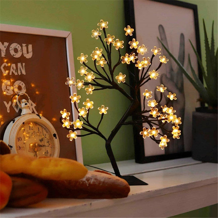Decorative USB LED Cherry Blossom Tree table lamp, ideal as a night light on a bedside table.