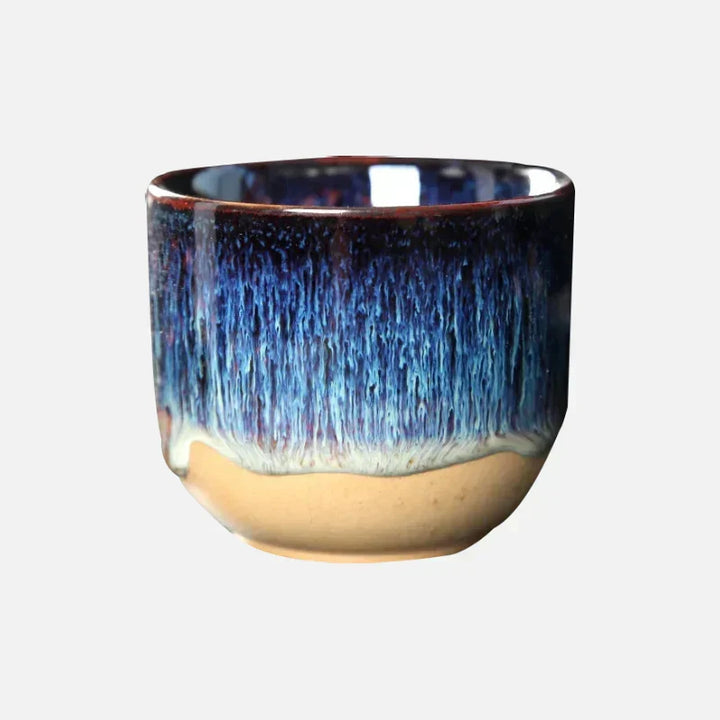 Ceramic kitchenware: tea cup with artistic splatter design and vibrant colors.