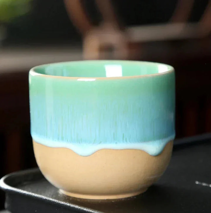Durable ceramic tea cup with a vibrant glaze finish and artistic splatter.