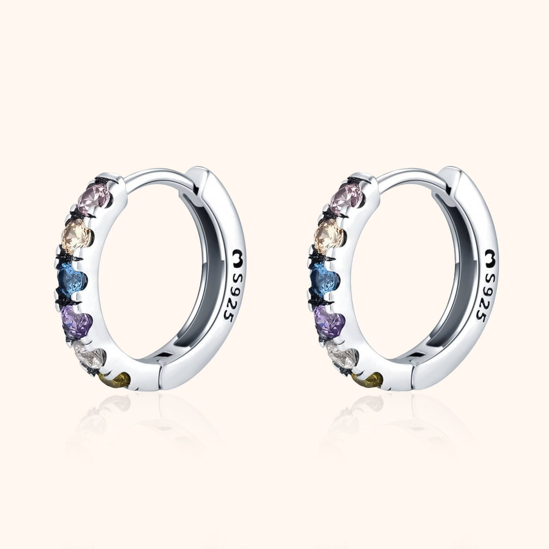 Close-up of colorful zirconia huggie earrings, beautiful and vibrant women's fashion jewelry.