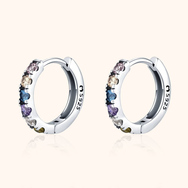 Close-up of colorful zirconia huggie earrings, beautiful and vibrant women's fashion jewelry.