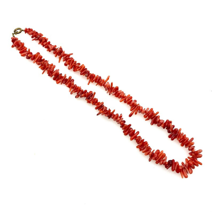 Close-up of a vibrant red coral bead necklace. This women's statement beaded jewelry is a perfect fashion accessory.