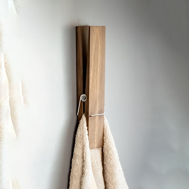 Close-up of wall-mounted wooden towel clip, natural grain, secure grip