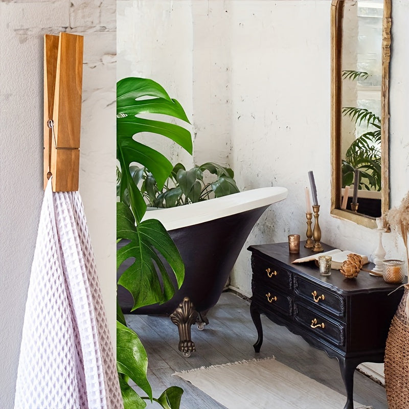Natural wood towel clip, WallClampia, mounted on a white wall, enhancing bathroom aesthetics