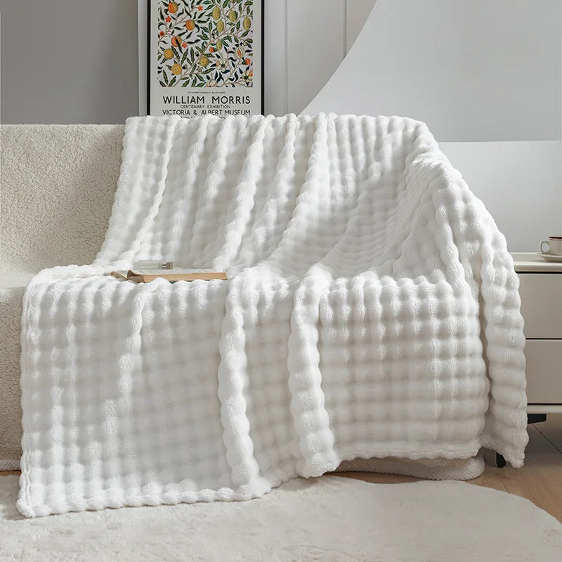 Soft textured fleece blanket, ideal as a comfortable and warm throw for bedding setups.