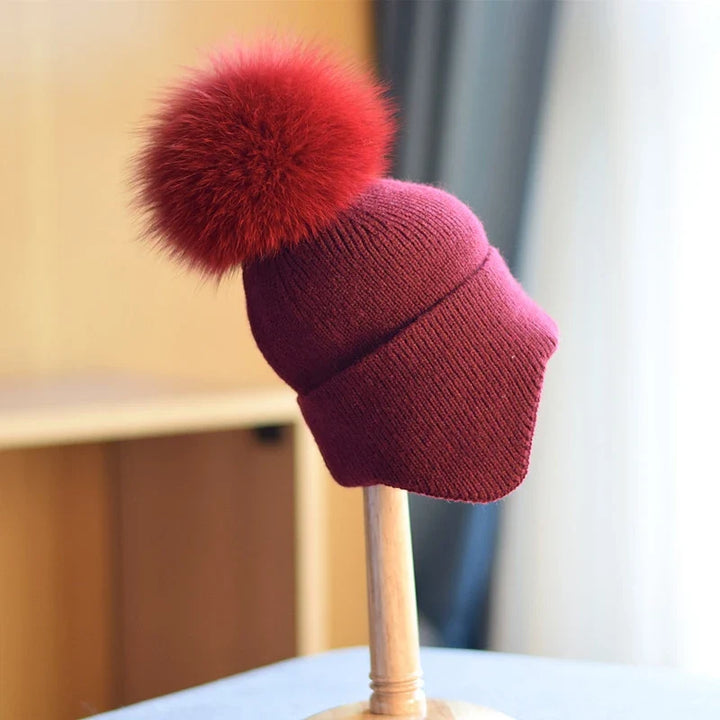 Cozy navy knit alpine pom beanie. Unisex warm winter hat, a stylish accessory for cold weather adventures.