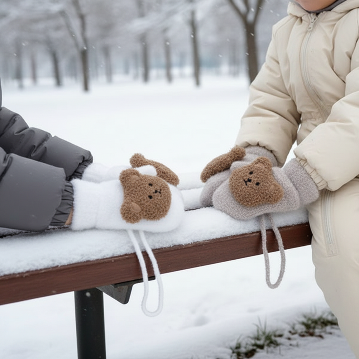 Warm knitted baby mittens in gray with connecting strap, perfect for winter.