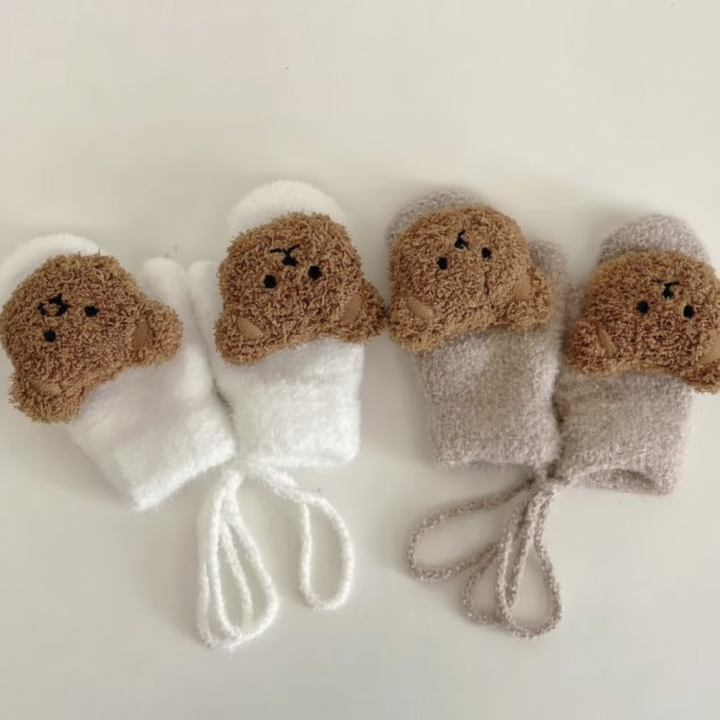 Cozy knitted baby gloves in blue with a practical strap to prevent loss.